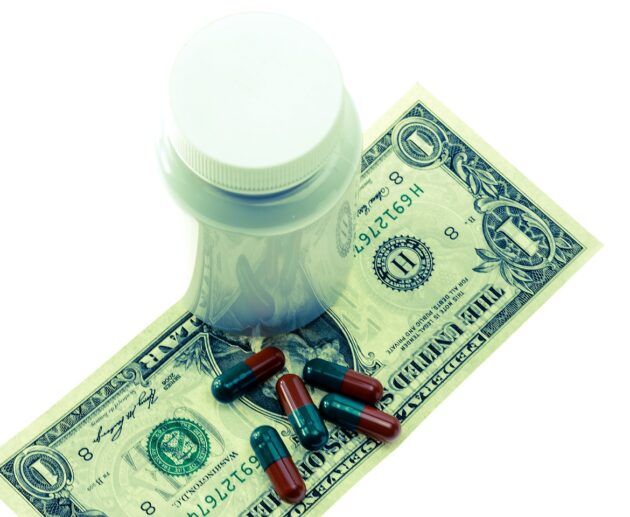 Pill Bottle On Top Of Dollar